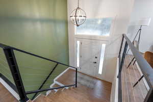 Entryway featuring a notable chandelier and wood-type flooring