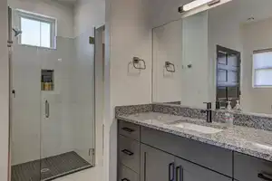 Bathroom with vanity, walk in shower, and a healthy amount of sunlight