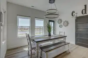 Dining space with a barn door, light hardwood / wood-style floors, and a healthy amount of sunlight