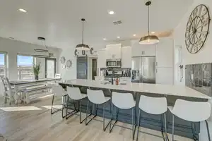 Kitchen featuring decorative light fixtures, light wood-type flooring, white cabinetry, and stainless steel appliances