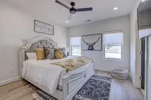 Bedroom with multiple windows, light wood-type flooring, and ceiling fan