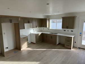 Kitchen featuring light hardwood / wood-style flooring, a textured ceiling, and sink