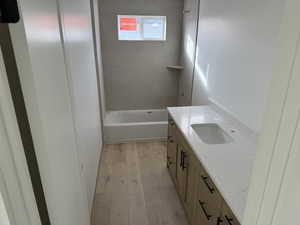 Bathroom featuring vanity, wood-type flooring, and tiled shower / bath