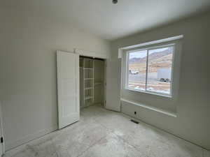 Unfurnished bedroom featuring a mountain view and a closet