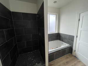 Bathroom featuring wood-type flooring and plus walk in shower