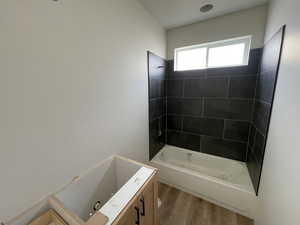 Bathroom featuring hardwood / wood-style floors and tiled shower / bath combo