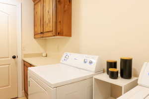 Laundry room featuring cabinets and washing machine and dryer