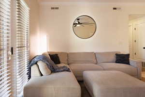 Living room with crown molding and ceiling fan