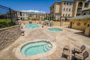 View of swimming pool with a mountain view, a patio, and a hot tub