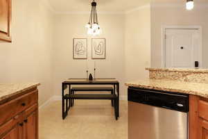 Dining space with light tile patterned flooring, a chandelier, and ornamental molding