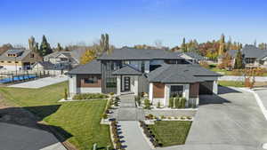 View of front of property with a garage and a front lawn