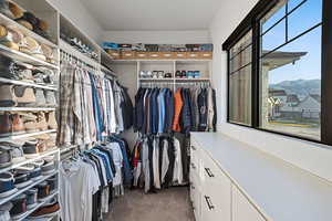 Spacious closet featuring dark colored carpet