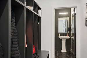 Mudroom with dark tile patterned flooring and tile walls