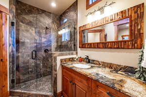 Bathroom with vanity and a shower with door