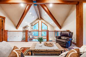 Living room featuring beam ceiling and high vaulted ceiling