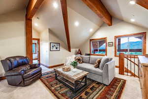 Living room featuring light colored carpet and lofted ceiling with beams