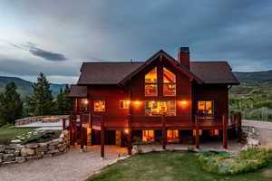 Back of property with a deck with mountain view