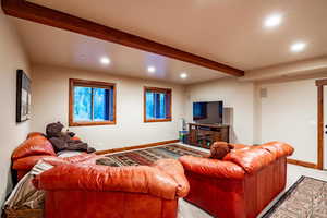 Carpeted living room with beam ceiling