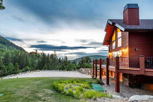 Yard at dusk featuring a deck with mountain view