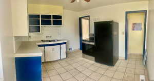 Kitchen featuring black appliances, white cabinets, sink, ceiling fan, and tasteful backsplash