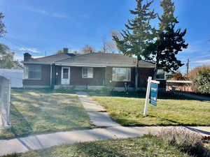 Single story home with a front lawn and covered porch