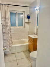 Full bathroom with tile patterned flooring, vanity, shower / tub combo, and toilet