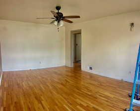 Empty room with light hardwood / wood-style floors and ceiling fan