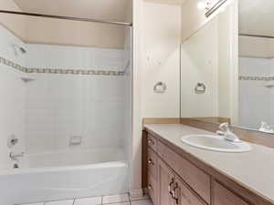 Bathroom with tile patterned flooring, vanity, and tiled shower / bath