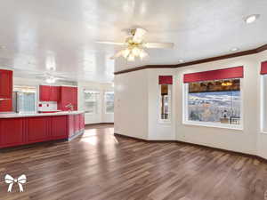 Unfurnished living room with a textured ceiling, sink, and dark hardwood / wood-style floors