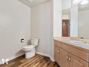 Bathroom featuring vanity, wood-type flooring, and toilet