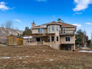 Rear view of property featuring a mountain view, a balcony, and solar panels