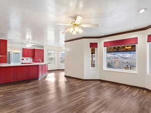 Unfurnished living room featuring crown molding, dark hardwood / wood-style flooring, a textured ceiling, and sink