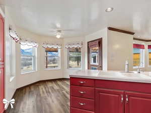 Kitchen with ceiling fan, sink, light hardwood / wood-style flooring, a textured ceiling, and ornamental molding