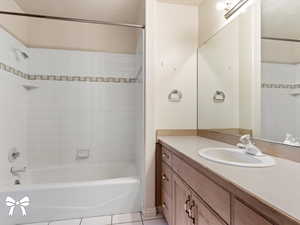 Bathroom with vanity, tiled shower / bath combo, and tile patterned floors