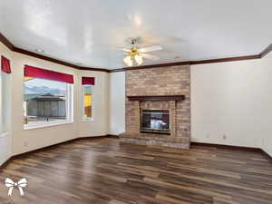 Unfurnished living room with a fireplace, ceiling fan, dark hardwood / wood-style flooring, and a textured ceiling