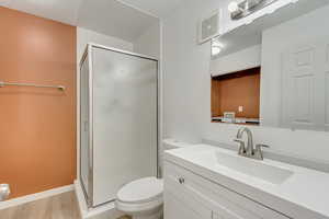 Bathroom featuring toilet, hardwood / wood-style floors, vanity, and walk in shower