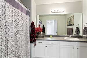 Bathroom with vanity and curtained shower