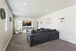 Living room featuring dark colored carpet