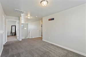 Spare room featuring carpet and a textured ceiling