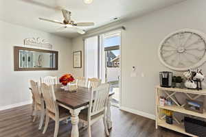 Dining space with dark hardwood / wood-style floors and ceiling fan