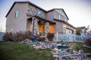 View of front of home with a front yard and a garage