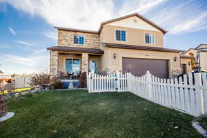 View of front of home with a front yard and a garage