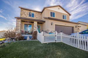 View of front of house featuring a garage and a front yard