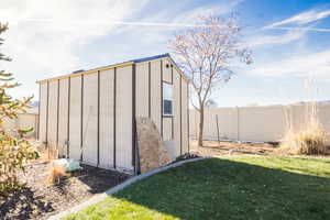 View of outbuilding featuring a lawn