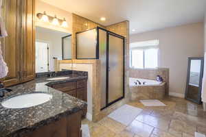 Bathroom featuring shower with separate bathtub and vanity