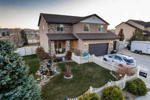 View of front facade with a lawn and a garage