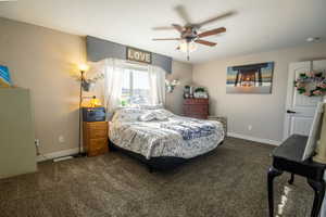 Bedroom with dark colored carpet and ceiling fan