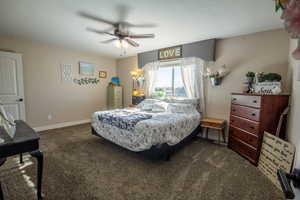 Bedroom featuring ceiling fan and dark colored carpet