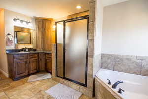 Bathroom featuring plus walk in shower and vanity