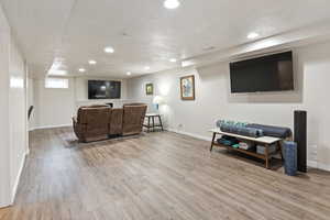 Living room with light hardwood / wood-style flooring and a textured ceiling